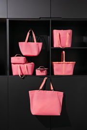 Verschiedene rosa Taschen in einem Regal, frontal betrachtet.