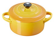 Gelbe Mini Cocotte von Le Creuset mit zwei Griffen und schwarzem Knauf, aus leicht erhöhter Perspektive
