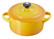 Gele mini-cocotte van Le Creuset met twee handvatten en een zwarte knop, vanuit een licht verhoogd perspectief