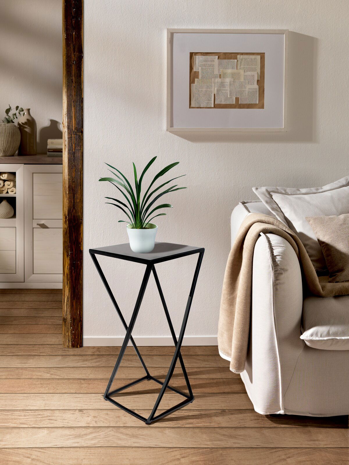 Moderner Beistelltisch mit schwarzem Metallgestell und quadratischer Platte, seitliche Perspektive, dekoriert mit einer Pflanze, in einem gemütlichen Wohnzimmer.