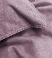 Nahaufnahme von lila Bettwäsche mit sichtbaren Nähten und weicher Textur