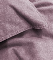 Nahaufnahme von lila Bettwäsche mit sichtbaren Nähten und weicher Textur