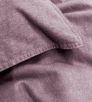 Nahaufnahme von lila Bettwäsche mit sichtbaren Nähten und weicher Textur