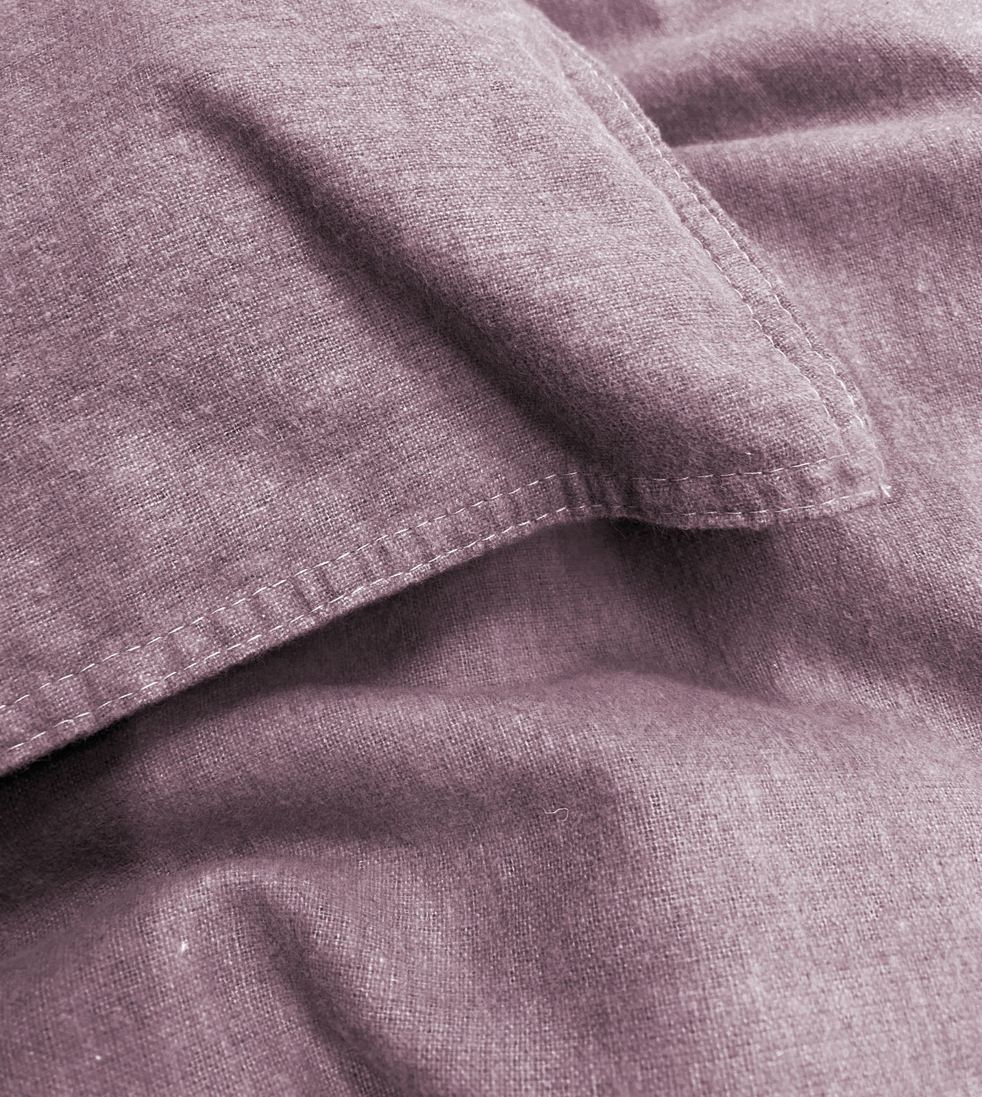 Nahaufnahme von lila Bettwäsche mit sichtbaren Nähten und weicher Textur