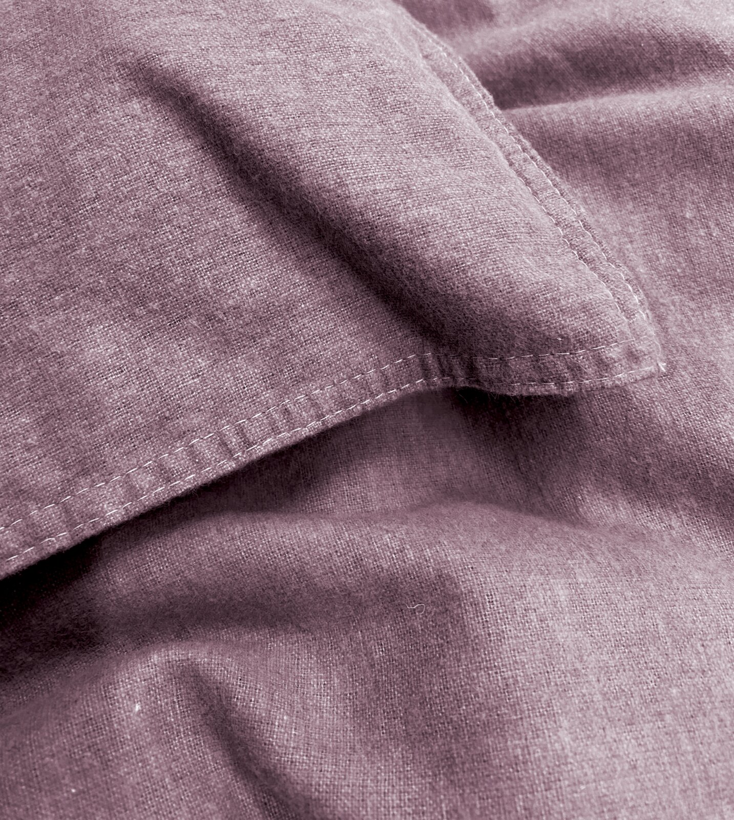 Close-up van paars beddengoed met zichtbare naden en een zachte textuur