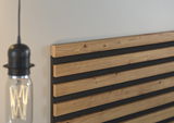 Nahaufnahme eines Akustikpaneels mit Holzlatten und schwarzem Filz, seitliche Perspektive.