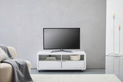 Weißes TV-Lowboard mit zwei offenen Fächern und zwei Schubladen, darauf steht ein Flachbildfernseher, frontal fotografiert.