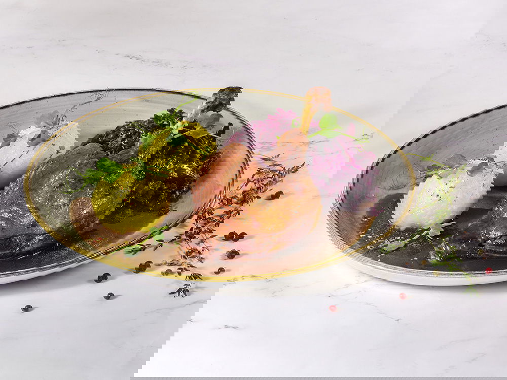 Gebratene Entenkeule mit Kartoffelklößen, Rotkohl und Bratensauce.