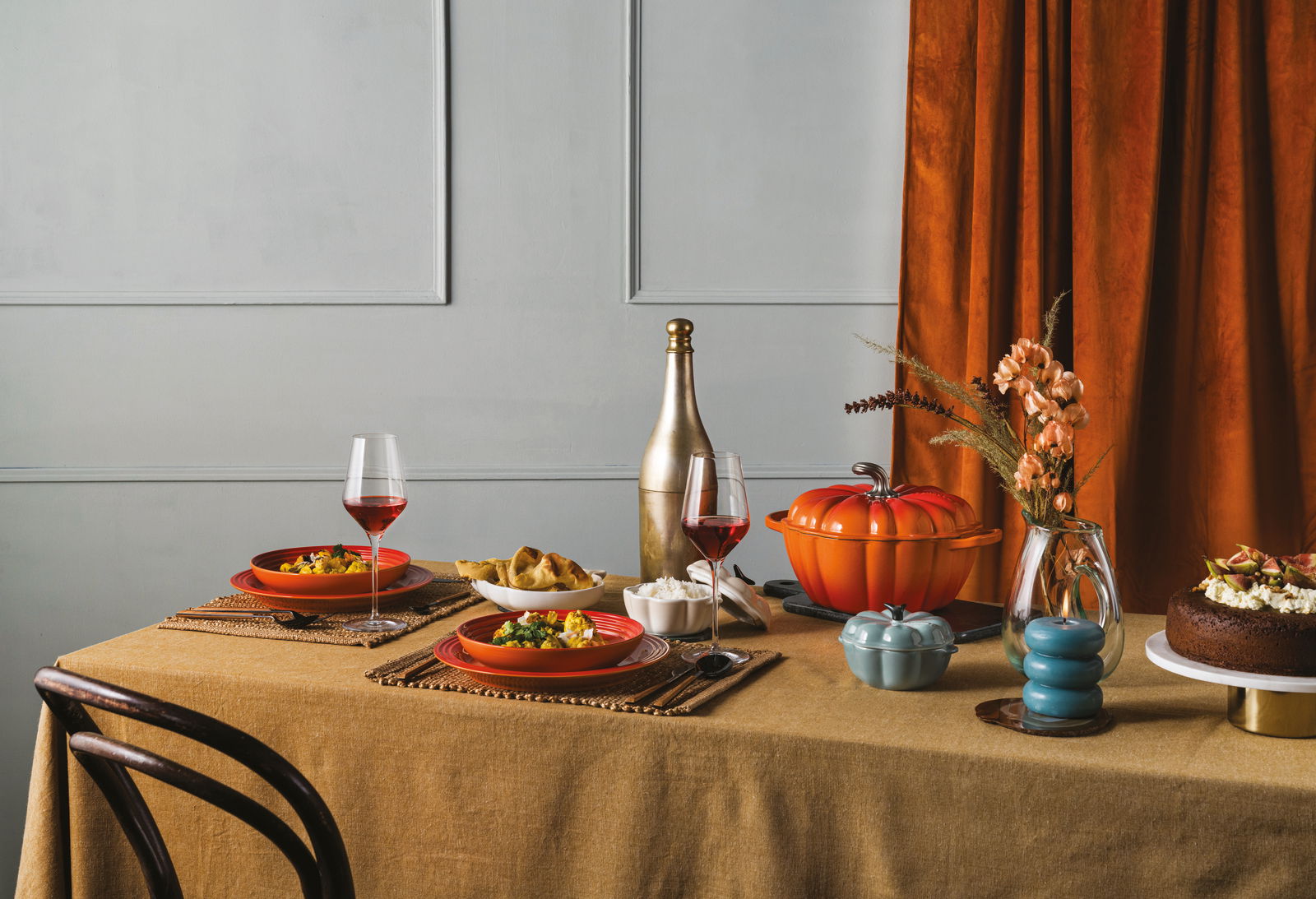 Kürbis-Bräter 24cm in ofenrot auf einem gedeckten Tisch, seitliche Perspektive