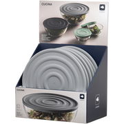 Grauer Silikondeckel in 28 cm Durchmesser, präsentiert in einer Verkaufsverpackung. Der Deckel ist auf einer Glasschüssel platziert, die mit Salat gefüllt ist. Perspektive: Frontalansicht der Verpackung.