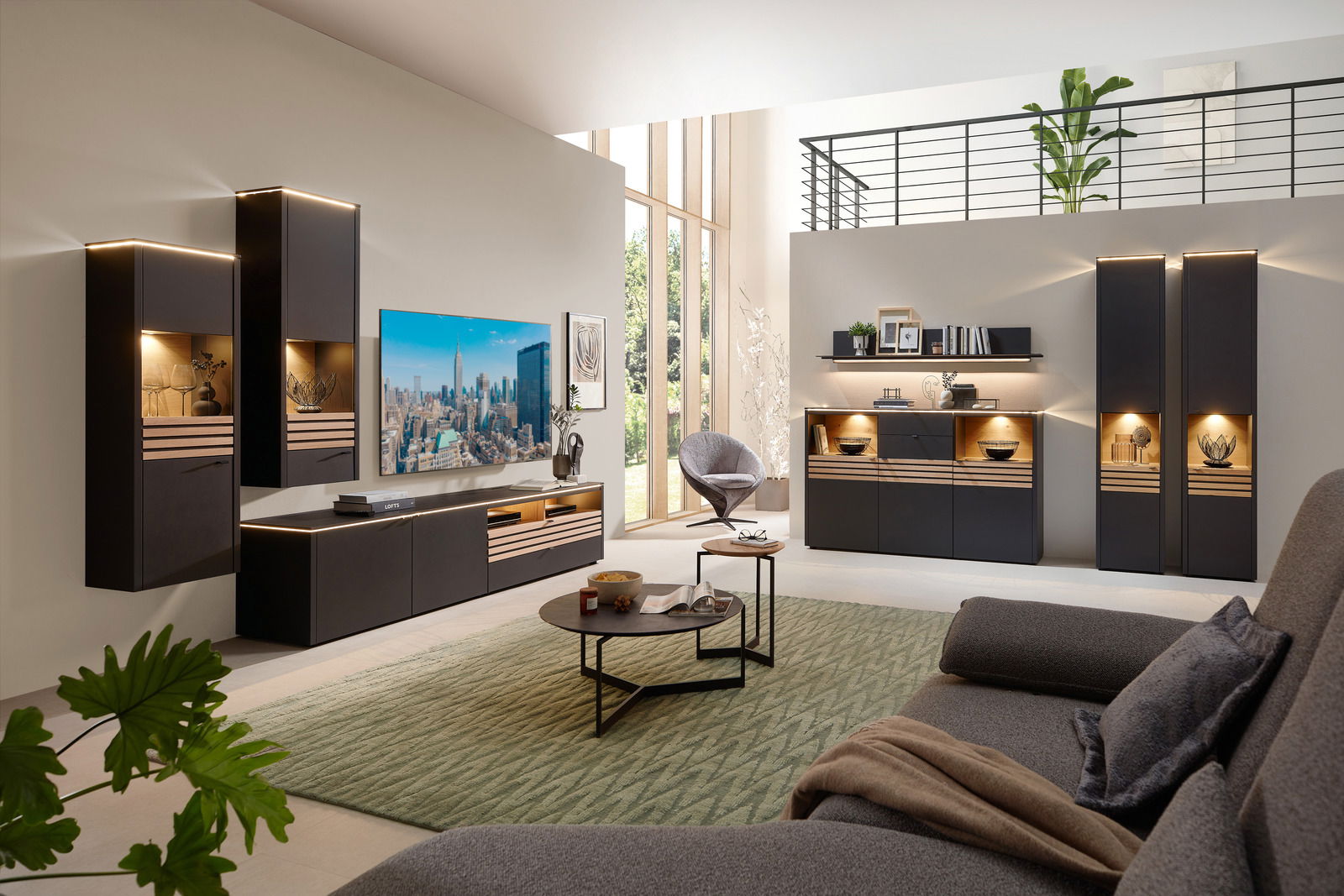 Moderne Wohnzimmermöbel mit LED-Beleuchtung, bestehend aus Hängeschränken, einem TV-Board und einem Couchtisch, aus der Perspektive eines gemütlichen Wohnzimmers mit Blick auf eine große Fensterfront.