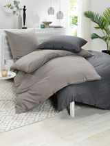 Bettwäsche-Set in Grau- und Anthrazittönen auf einem Bett, seitliche Perspektive