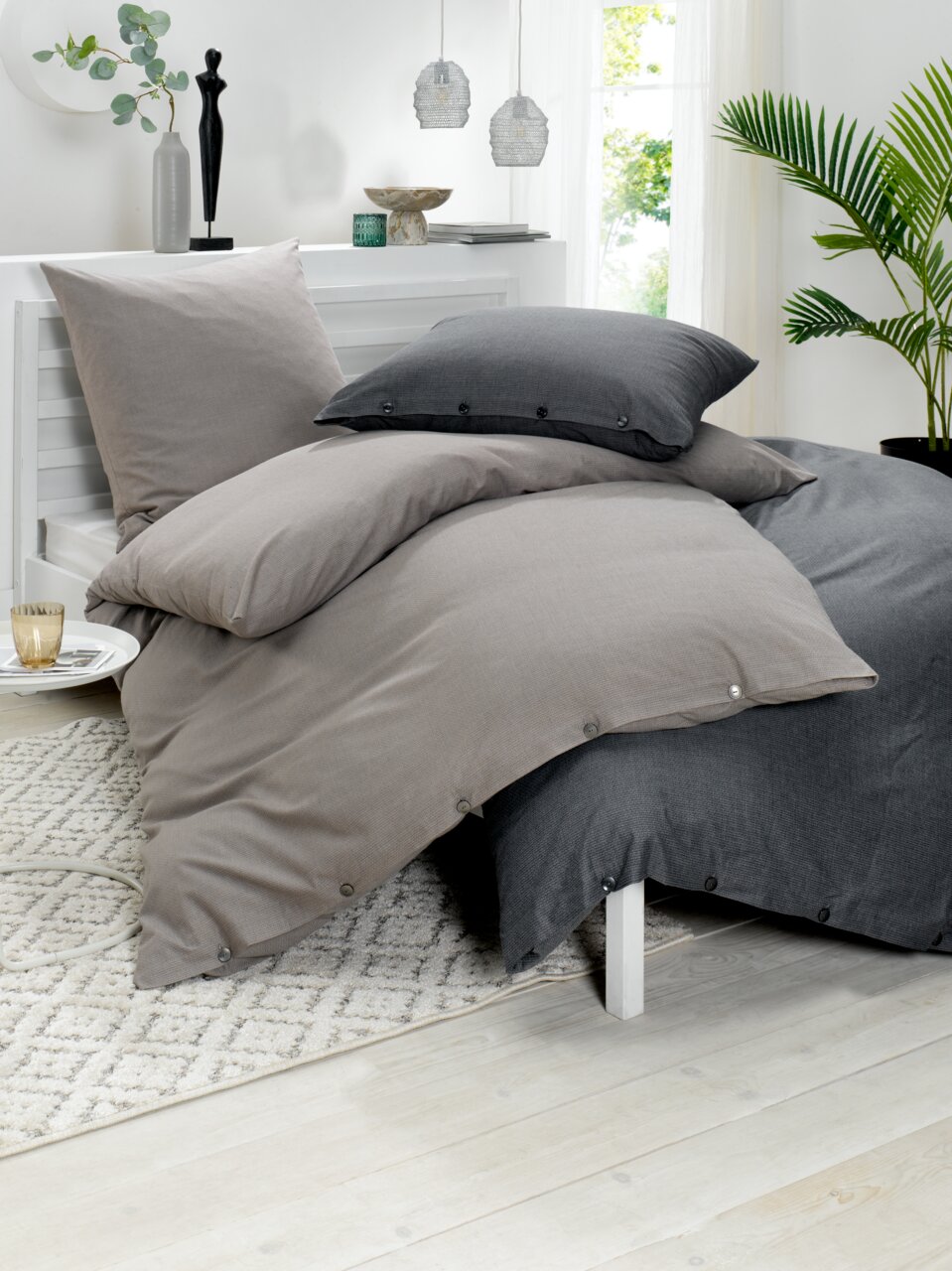 Bettwäsche-Set in Grau- und Anthrazittönen auf einem Bett, seitliche Perspektive