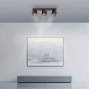 Deckenansicht eines modernen LED-Spots mit drei verstellbaren Leuchten in einem minimalistischen Raum.