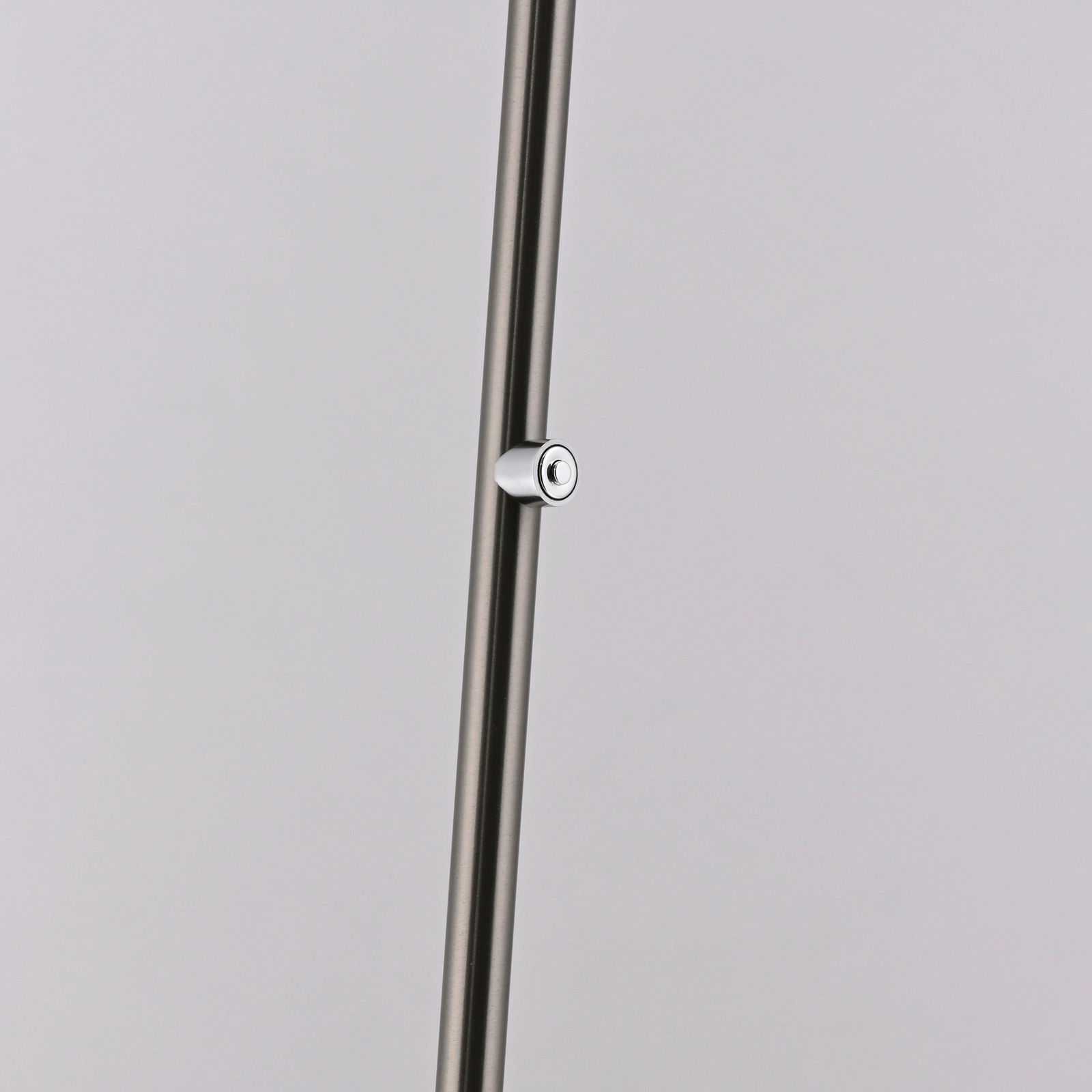 Nahaufnahme eines schlanken, metallischen Stabs mit einem kleinen, runden Schalter, Teil der Akku-Stehleuchte BENTE.