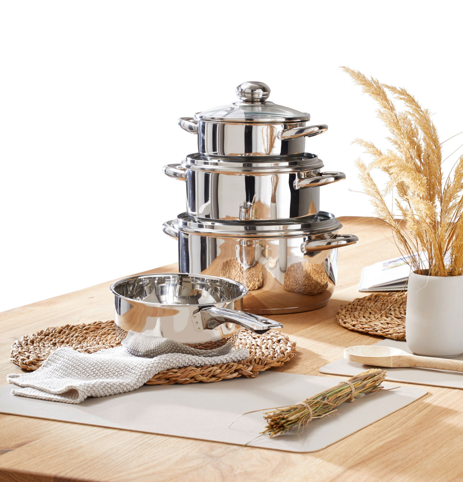 Edelstahl Kochtopfset, 4-teilig, auf einem Holztisch arrangiert, seitliche Perspektive