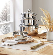 Edelstahl Kochtopfset, 4-teilig, auf einem Holztisch arrangiert, seitliche Perspektive