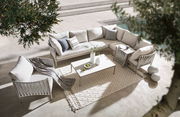 Loungetisch in moderner Outdoor-Lounge mit beigen Sofas und Kissen, von oben fotografiert.