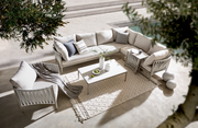 Loungetisch in moderner Outdoor-Lounge mit beigen Sofas und Kissen, von oben fotografiert.