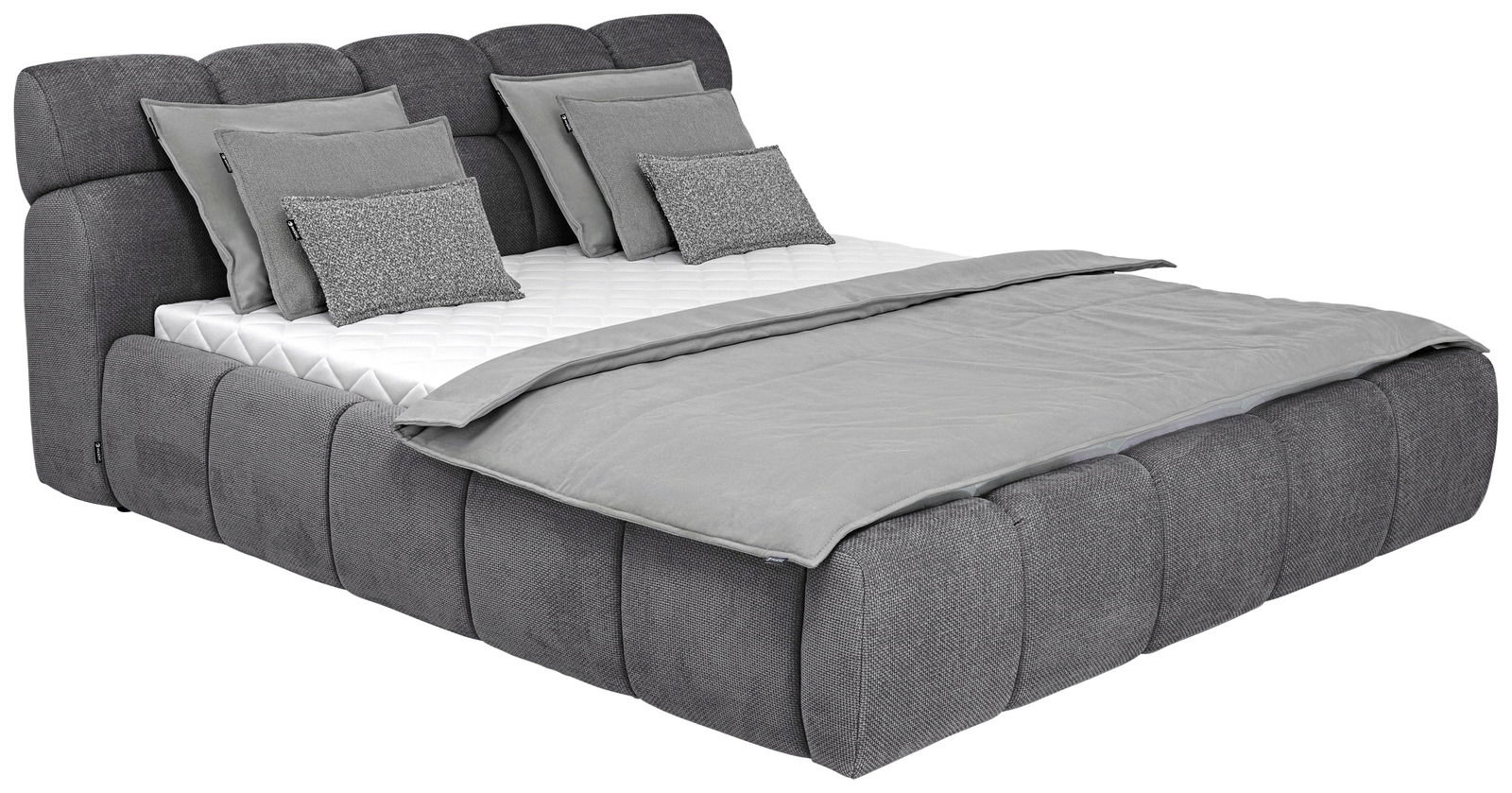 Graues Polsterbettgestell mit mehreren Kissen und Decke, seitliche Perspektive