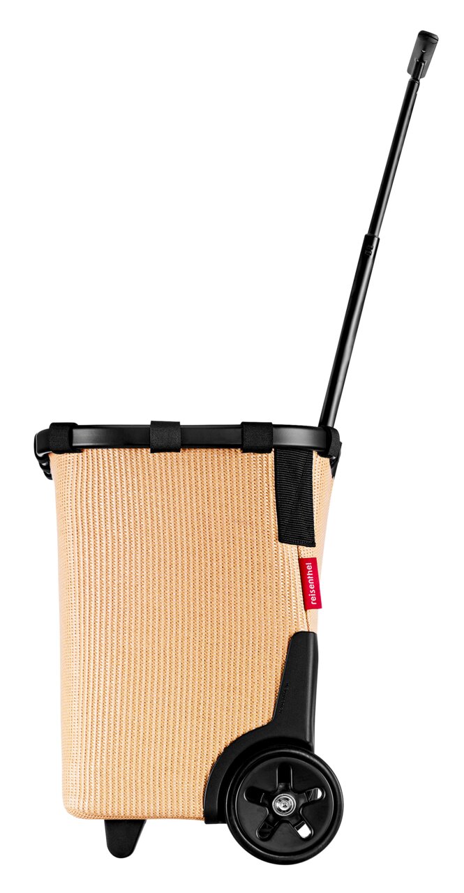 Zijaanzicht van een beige carrycruiser met een zwart handvat en wielen.