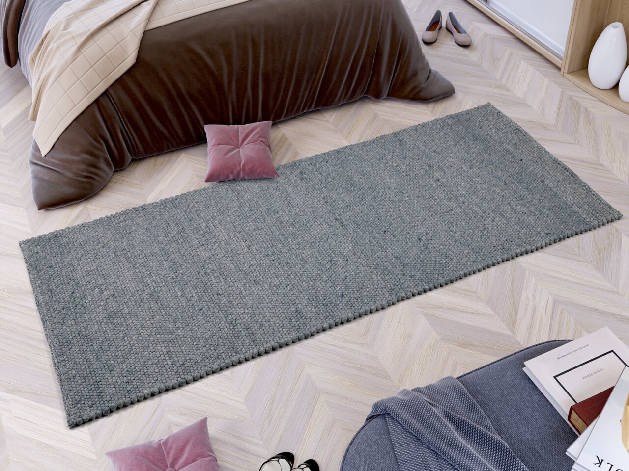 Handgewebter Teppich in rechteckiger Form, in einem modernen Schlafzimmer auf hellem Holzboden platziert, aus der Vogelperspektive fotografiert.