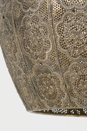 Detailansicht einer kunstvoll verzierten Hängeleuchte mit filigranem Muster in goldener Farbe.