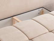 Nahaufnahme eines Schlafsofas mit beigem Stoffbezug und sichtbarer Holzstruktur, Perspektive von oben.