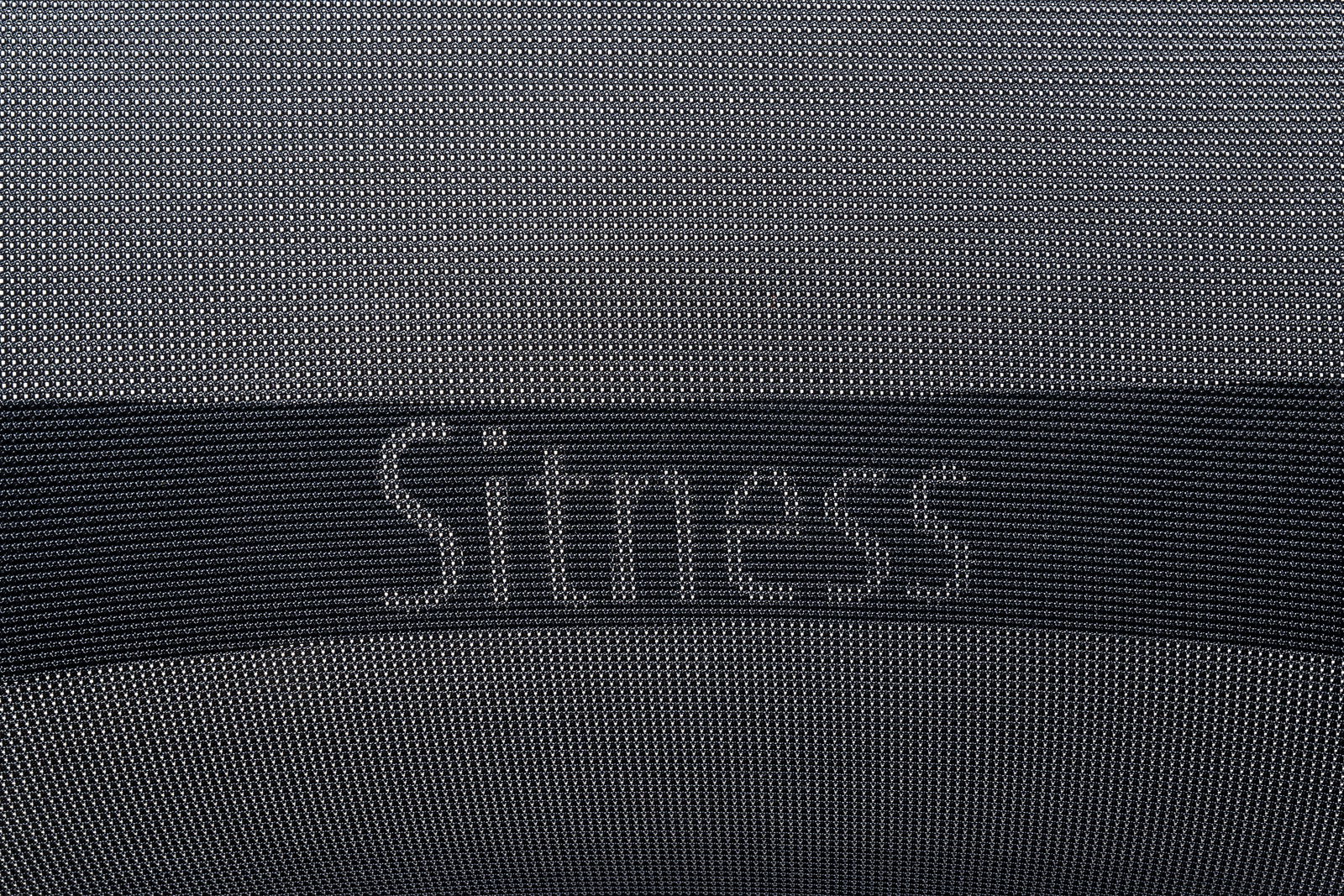 Nahaufnahme der Rückenlehne eines Bürostuhls mit dem Schriftzug 'Sitness'.