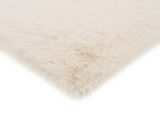 Weißer Fellteppich in Nahaufnahme, perspektivisch von der Seite fotografiert.