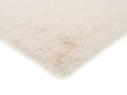 Weißer Fellteppich in Nahaufnahme, perspektivisch von der Seite fotografiert.