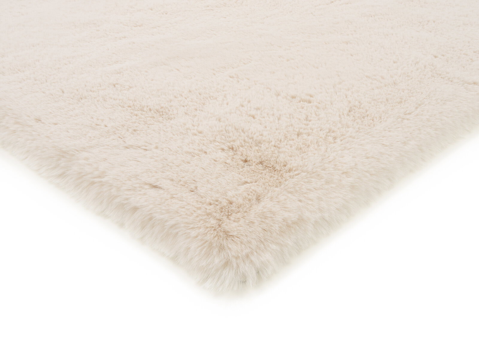 Weißer Fellteppich in Nahaufnahme, perspektivisch von der Seite fotografiert.