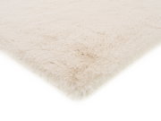 Weißer Fellteppich in Nahaufnahme, perspektivisch von der Seite fotografiert.