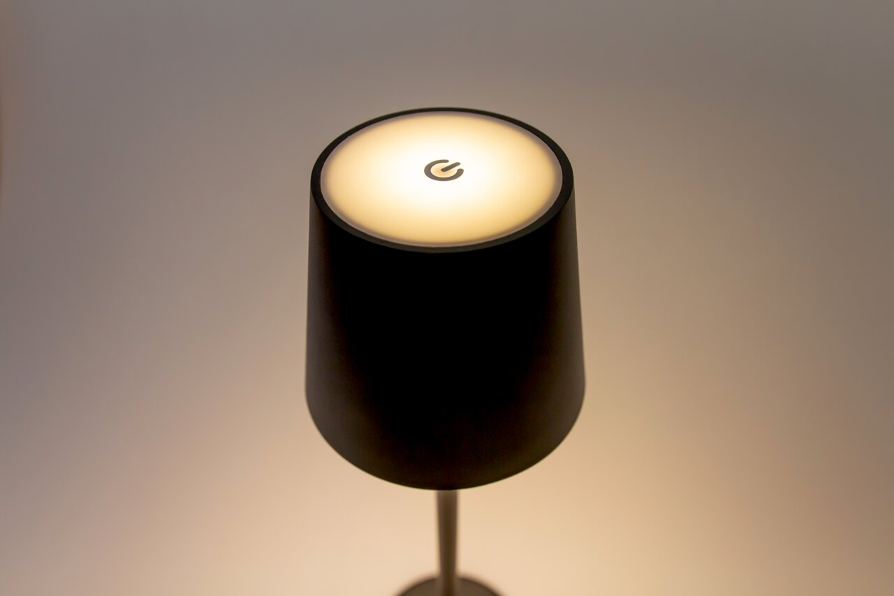 Moderne Akku-Tischleuchte in Schwarz mit leuchtendem Schirm und Touch-Schalter, Ansicht von oben