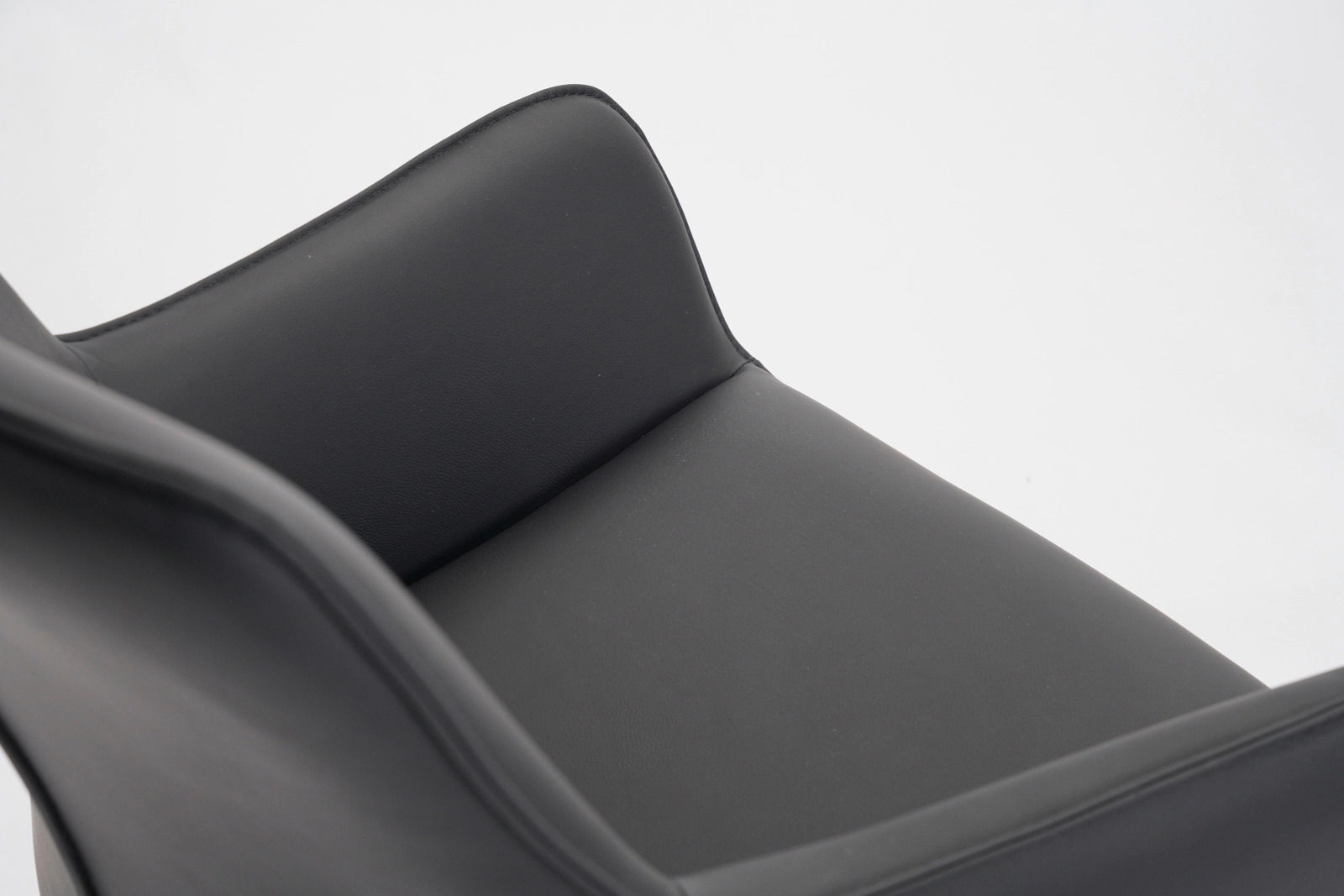 Nahaufnahme eines schwarzen Barhockersitzes aus Leder, von oben betrachtet.