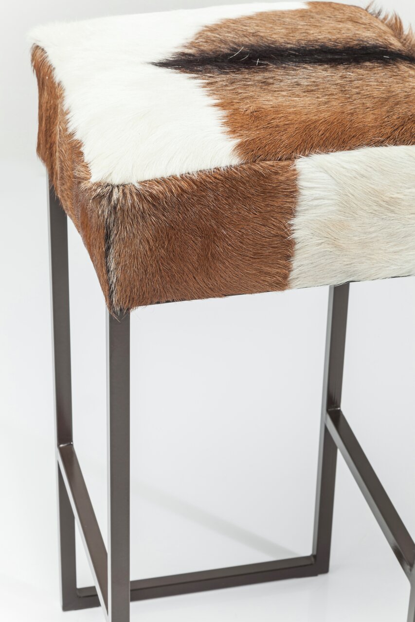 Hocker mit braun-weißer Felloberfläche und Metallgestell, seitliche Perspektive