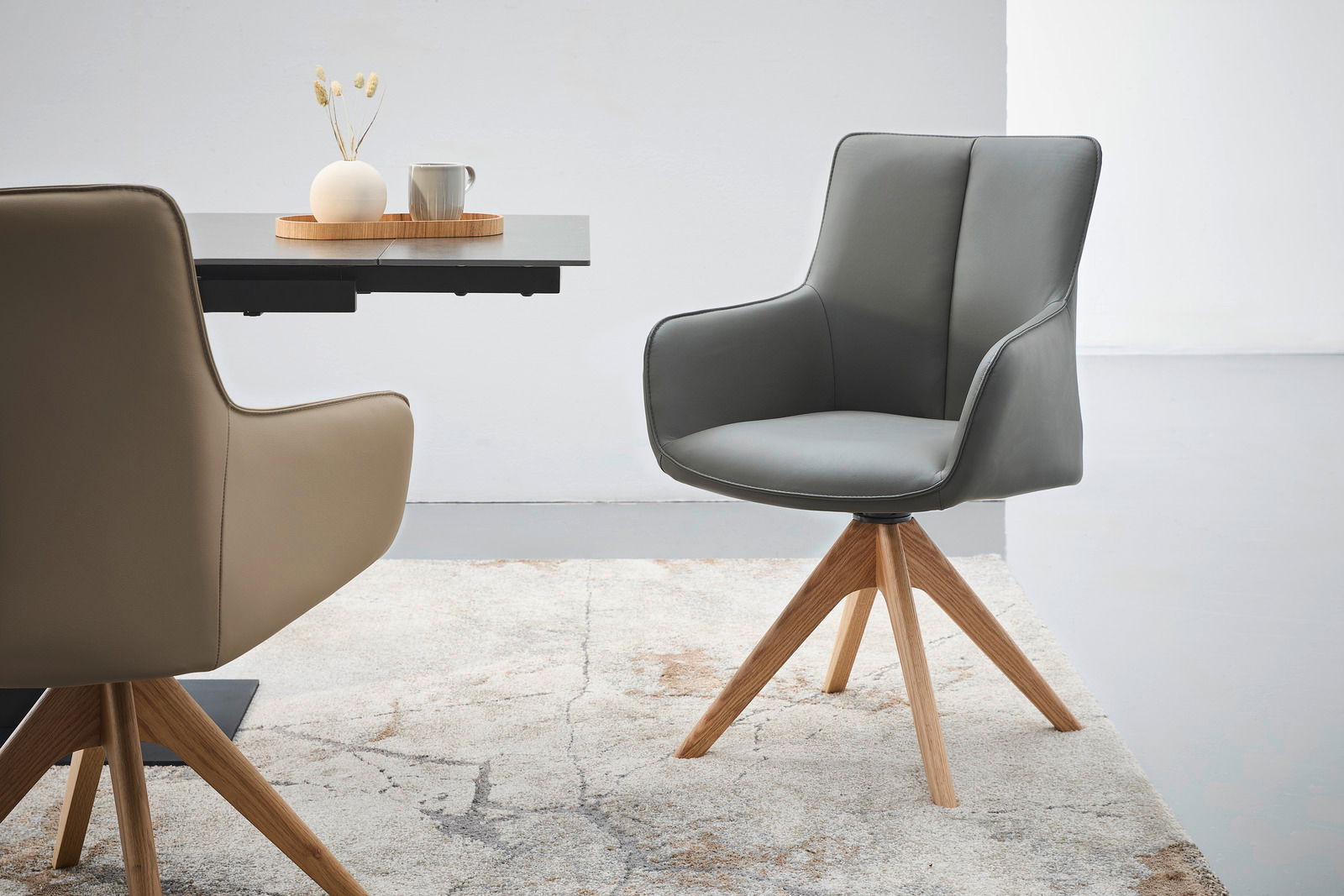 Moderner Armlehnstuhl mit grauem Polster und Holzbeinen, seitliche Perspektive