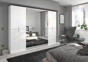 Moderne Garderobenkombination mit weißen Hochglanzfronten und Spiegeln, perspektivisch von der Seite im Schlafzimmer betrachtet.