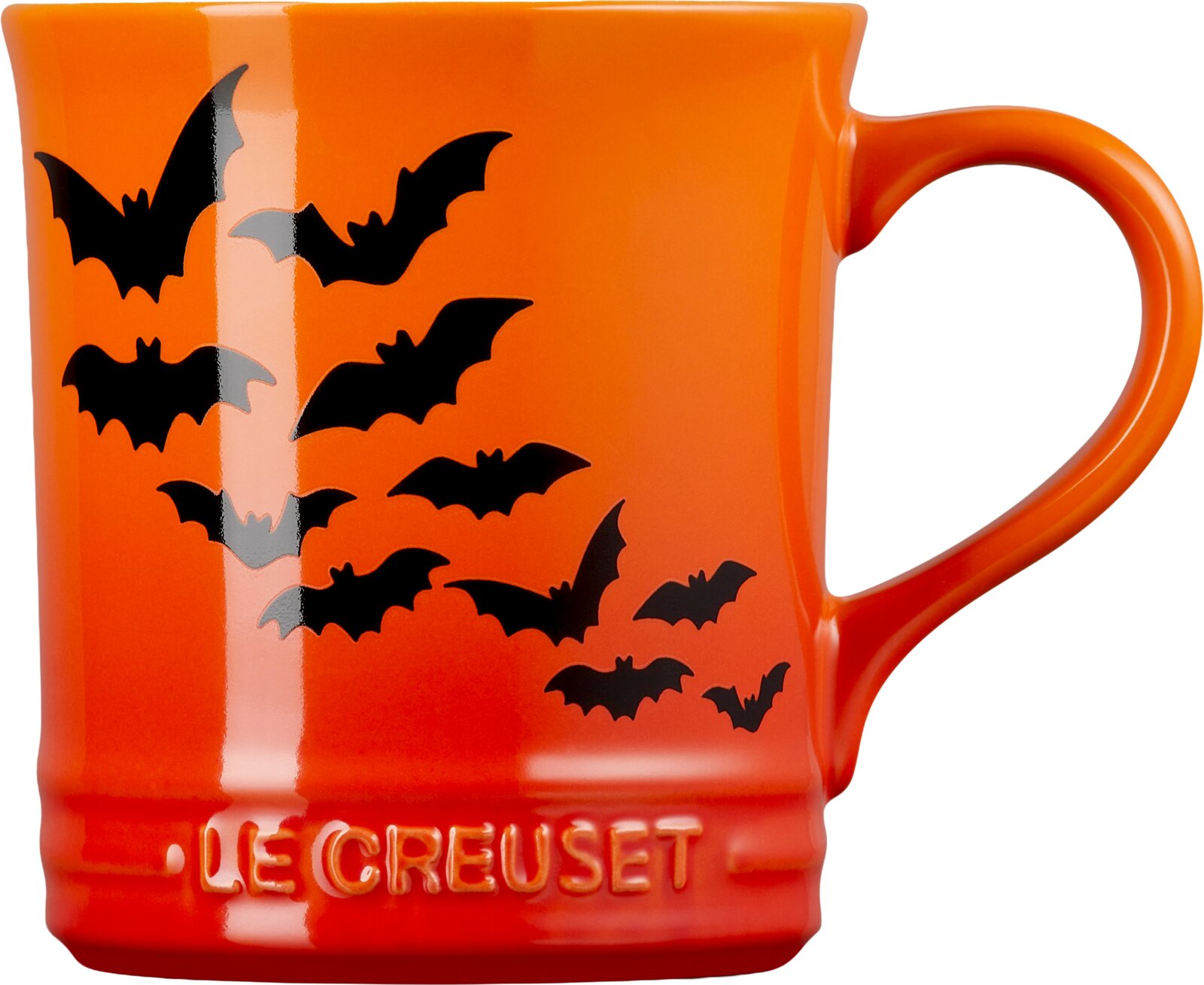 Orangefarbene Le Creuset Tasse mit schwarzen Fledermausmotiven und großem Henkel, frontal aus leichter Seitenperspektive