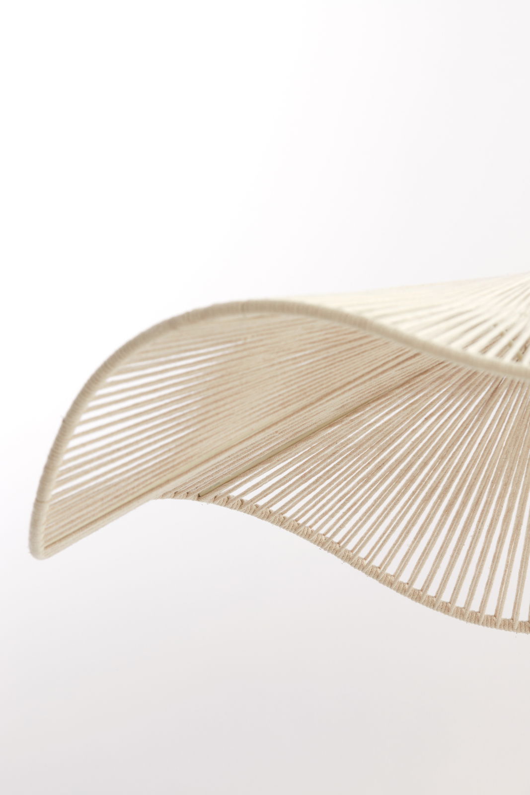 Nahaufnahme einer Hängeleuchte mit geschwungenem, fächerförmigem Design aus beigem Material, seitliche Perspektive