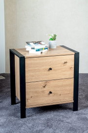Moderne Kommode mit zwei Schubladen in Eichenholz-Optik und schwarzem Rahmen, frontal leicht von oben fotografiert; oben liegen Bücher und ein kleiner Blumentopf.