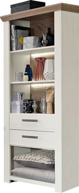 Weißes Regal mit mehreren Fächern, dekoriert mit Büchern, Vasen und einer Kamera, aus frontaler Perspektive.