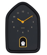 Schwarze Wanduhr in Hausform mit gelben Zeigern und einer kleinen Hundefigur in einer Aussparung unten, Frontalansicht.