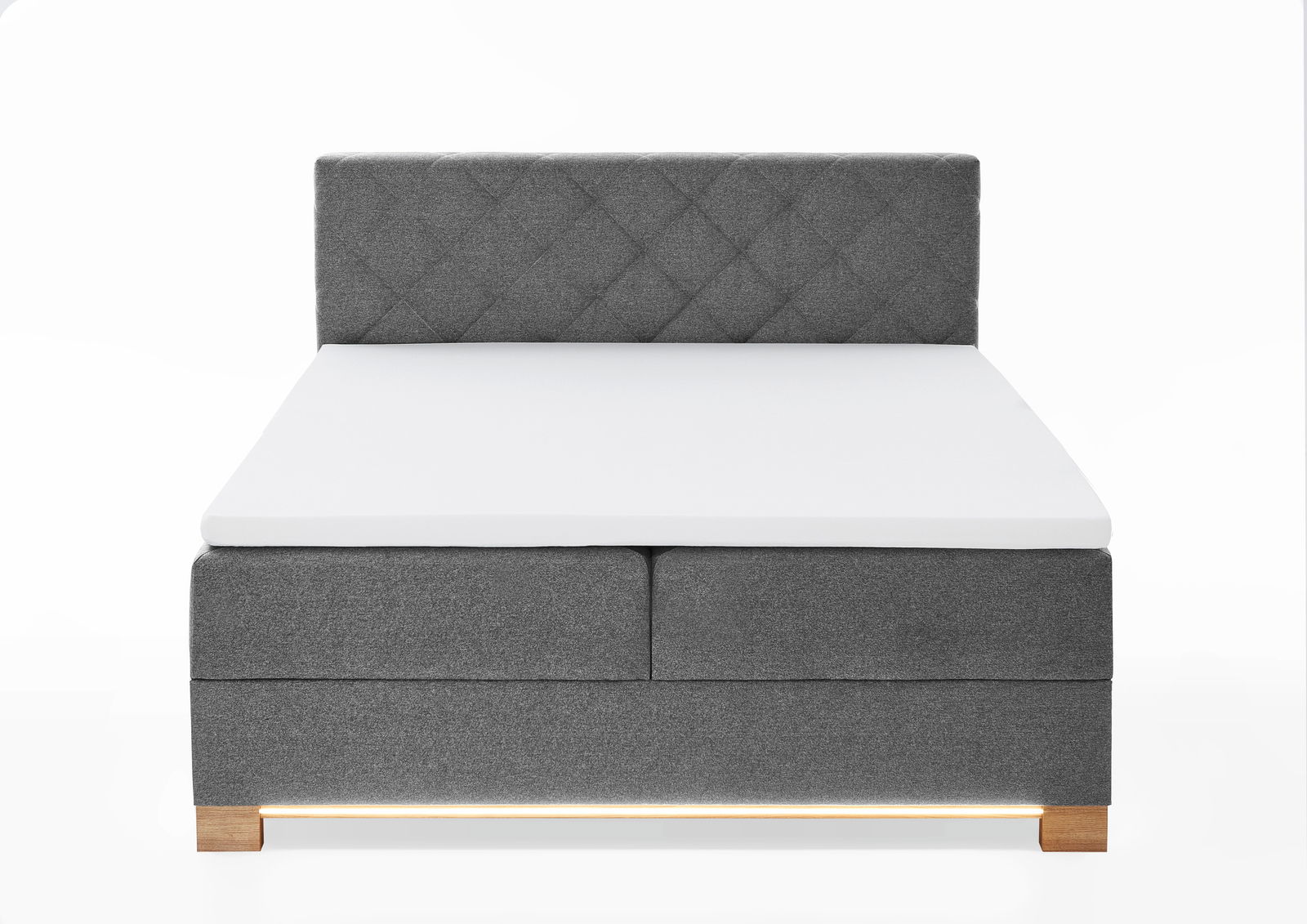 Frontale Ansicht eines grauen Boxspringbetts mit gestepptem Kopfteil und Holzfüßen.