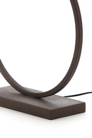 Nahaufnahme eines modernen, runden Lampenfußes aus dunklem Material mit rechteckiger Basis, seitliche Perspektive.