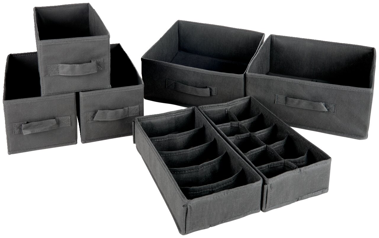 Set van zeven zwarte opbergdozen in verschillende maten, gefotografeerd van voren en licht van bovenaf.