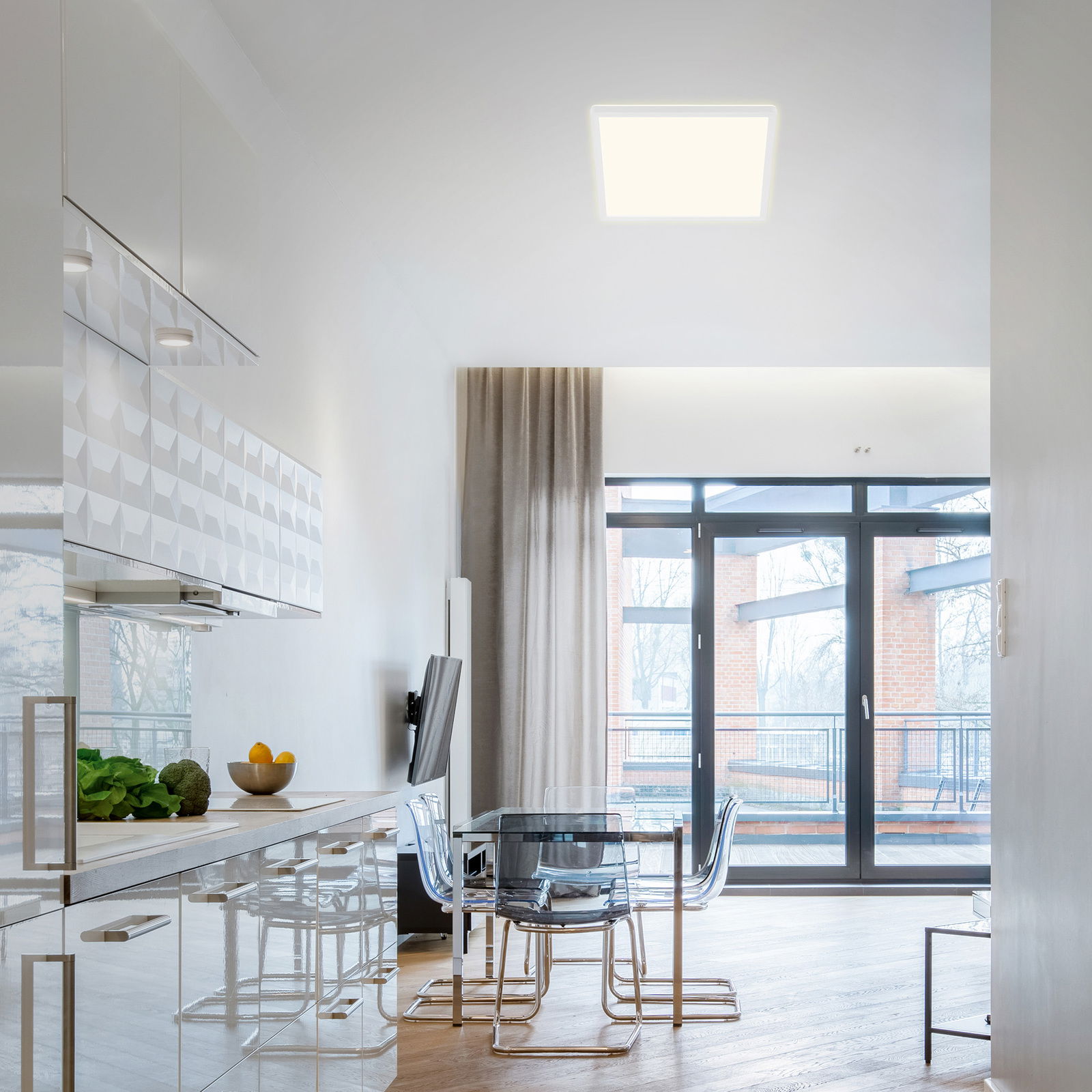 Moderne LED-Deckenleuchte in einem hellen, stilvollen Raum mit Blick auf die Küche und den Essbereich.