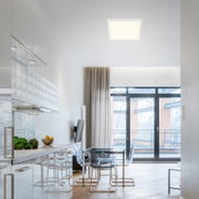 Moderne led-plafondlamp in een lichte, stijlvolle ruimte met uitzicht op de keuken en de eethoek.