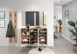 Mehrzweckschrank in einem modernen Flur, frontal fotografiert, mit offenen Türen, die verschiedene Fächer mit Schuhen und Accessoires zeigen.