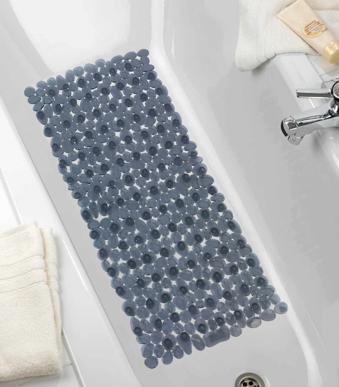 Perspektive von oben auf eine graue Wanneneinlage mit runden Noppen in einer weißen Badewanne.
